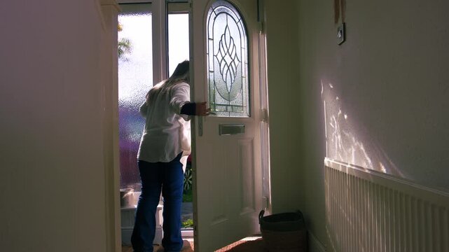 Woman looking out of house front door