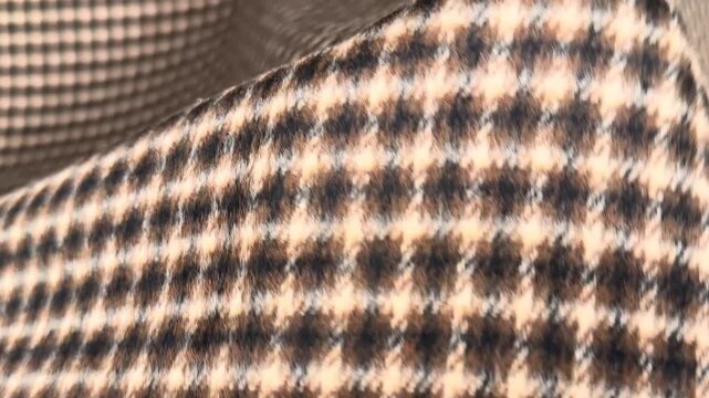 This durable polyester fabric features a classic brown and beige houndstooth pattern with a structured finish making it ideal for creating professional blazers skirts and tailored autumn suits