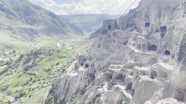 Vardzia cave monastery complex excavated from Erusheti Mountain. Ancient historic rock-cut architecture landscape over a green river valley in Georgia