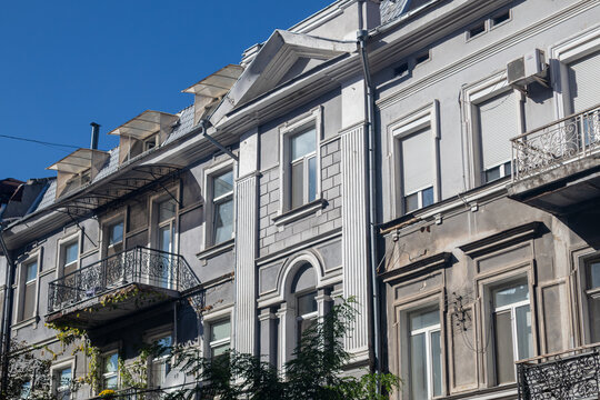 Historic apartment buildings with ornate details and balconies under clear blue sky