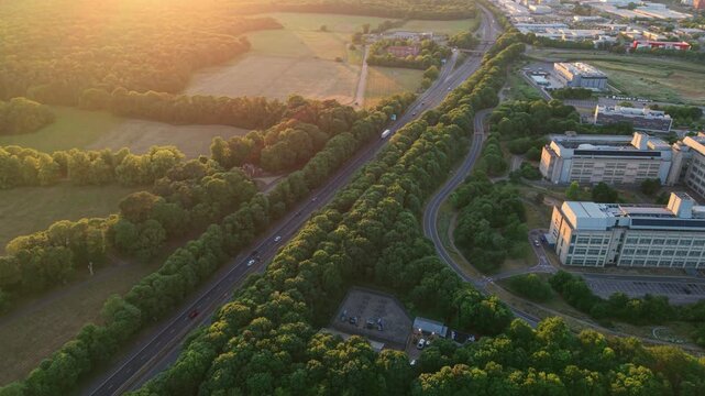 Aerial view of the GSK corporate building and busy traffic on the A1 road at sunset, UK.