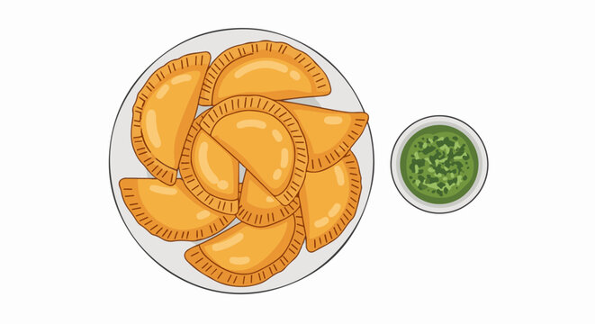 Golden empanadas arranged on a plate next to a bowl of green sauce