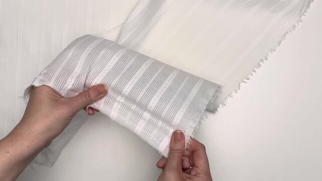 This white cotton eyelet fabric features a lightweight weave with a decorative stripe pattern and breathable texture making it an ideal choice for comfortable summer clothing and apparel for children