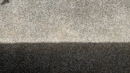 Fototapeta premium Modern abstract background of sharp dark shadows and bright sunlight on textured concrete surface with copy space.