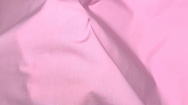 This pink cotton fabric features a plain weave and natural composition suitable for clothing construction and textile projects with a soft texture and matte finish.