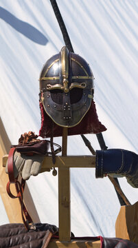 Historical Viking helmet with chain mail and leather armor on a wooden stand