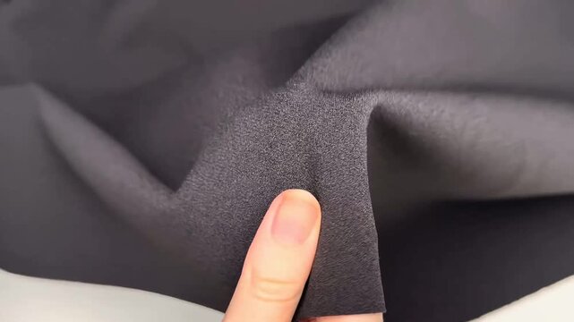 High density black knit fabric featuring crepe texture with comfortable drape and durable stretch suitable for professional apparel construction projects and garment design needs