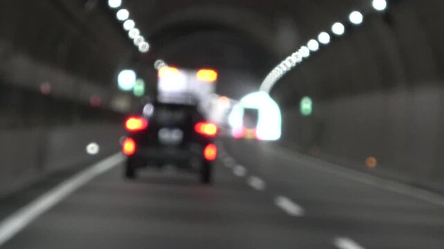 高速道路、トンネル内を走行する自動車　バックライト ぼかし背景の映像素材