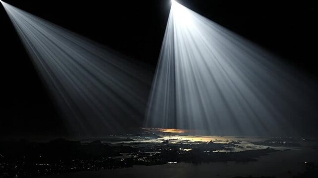 Bright searchlights illuminate the dark night sky above a landscape