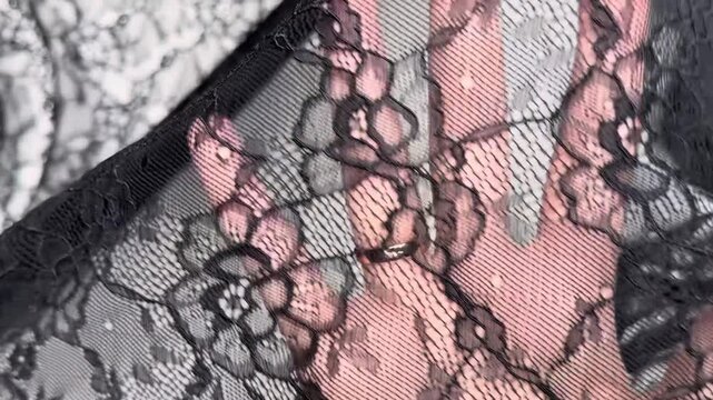 The sheer black venice lace textile showcases an intricate floral pattern on a soft stretch mesh base making it perfect for elegant apparel and delicate trim accents.