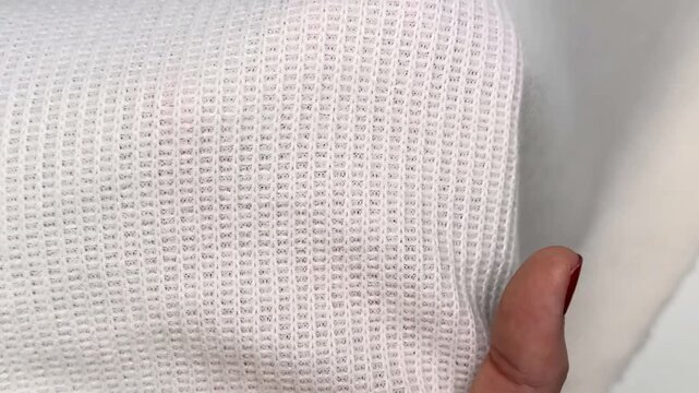 White waffle knit fabric close up showing soft relief texture stretchable surface pattern and lightweight material suitable for apparel and garment sewing