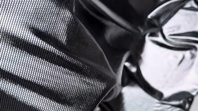 Close up of a brilliant silver textile featuring a fine mesh pattern displaying excellent stretch and smooth draping qualities while catching the light beautifully.