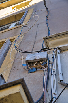 Messy cable installation on an old house facade.