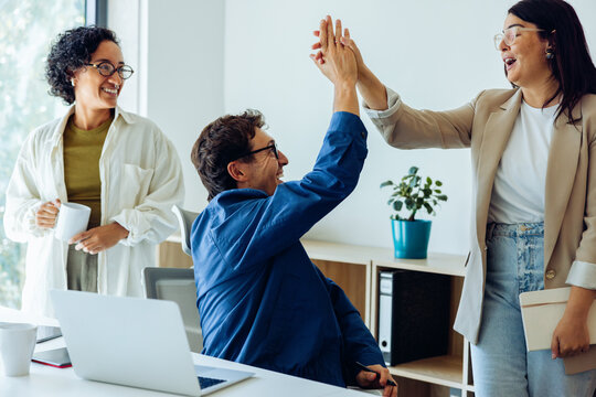 Business colleagues celebrate success with a high five