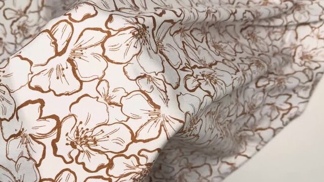 Soft woven rayon textile featuring a delicate botanical illustration in brown ink over a pale background suitable for lightweight summer clothing and dressmaking projects.