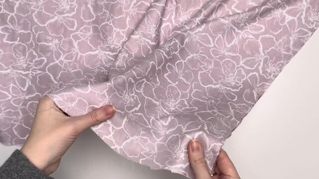 Soft woven rayon textile featuring a delicate botanical illustration in white ink over a dusty pink background suitable for lightweight summer clothing and dressmaking projects.
