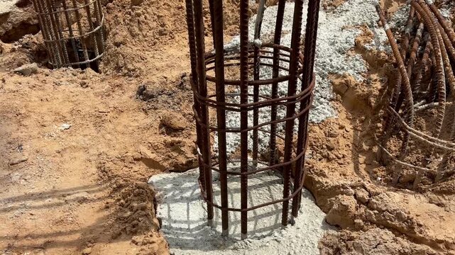 Reinforced concrete column foundation with steel rebar cage at construction site, structural engineering
