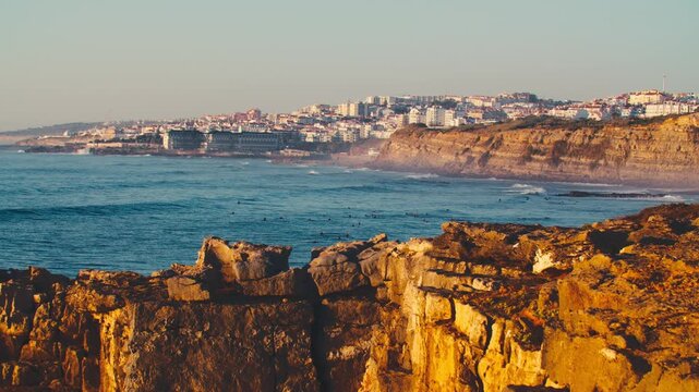 Beautiful view of the rocky coastal European city in the sunny evening sunset. Beautiful evening sunset on the background of the endless ocean. The concept of tourism and recreation.