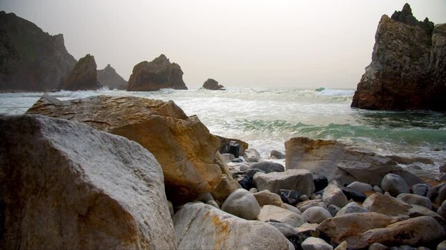 Beautiful rocky coast on the Atlantic coast. The famous Portuguese Ursa Beach. Beautiful panorama of the Rocky shore with incoming turquoise waves. Beautiful seascape on the background of rocks.