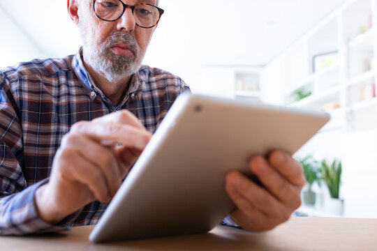 Senior man using digital tablet at home