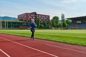 Obraz premium Young Woman In Hijab Running On Outdoor Track For Fitness And Healthy Lifestyle Training
