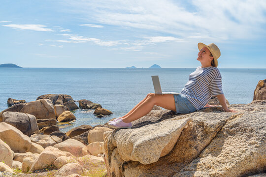 Woman is working on a laptop at a scenic location