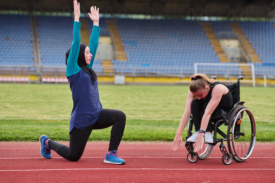 Adaptive Fitness Training On Track With Wheelchair Athlete And Coach Stretching Together