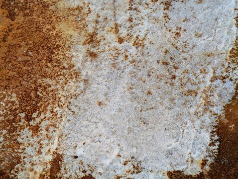 Close-up of a rusted metal surface showing natural corrosion, oxidation, and weathered textures in brown, orange, and gray tones, ideal for industrial backgrounds.