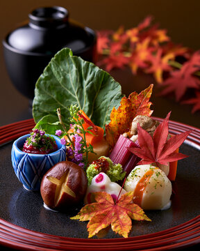 Multi-Course Japanese Kaiseki Autumn Spread with Colorful Bowls and Maple Garnish