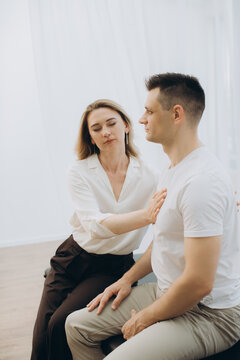 Woman practitioner performing theta healing on man client