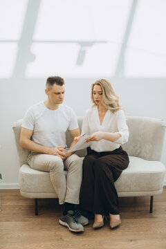 Woman consulting man discussing document sitting together