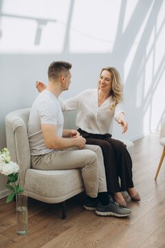 Woman smiling and talking to man during therapy session