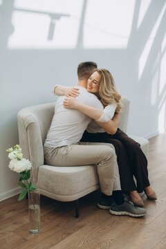 Happy couple hugging on couch for therapy session