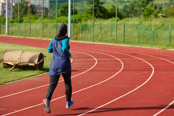 Fototapeta premium Muslim Woman Running On Outdoor Track Wearing Hijab Athletic Sportswear For Fitness Training