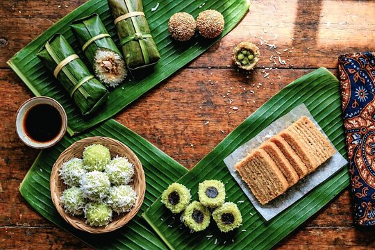 Assortment of Indonesian traditional snacks klepon lemper lapis legit on banana leaf