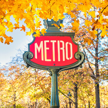 Metro subway station sign in Paris France with autumn fall leaves