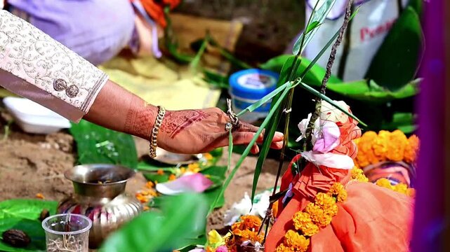 Close-up footage of a traditional Hindu wedding ceremony showing sacred marriage rituals performed by the bride, groom, family members, and priest. The ceremony includes religious customs
