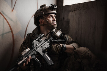 Obraz premium Military soldier Hide in a shelter with assault rifle, tactical operator in urban combat mission