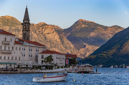 Classic postcard view of the timeless stone town of Perast bathed in the warm golden light of a summer sunset