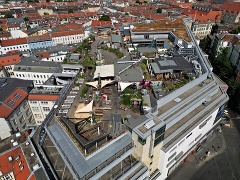 Aerial view of the Klunkerkranich rooftop garden and cultural space with wooden decks and sunshades overlooking the urban landscape of Berlin, Berlin, Germany.
