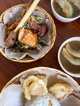 'Nasi Campur Bali' is a Balinese, Indonesian specialty consisting of steamed rice, stir-fried vegetables, roasted pork, crispy pork skin, crackers, offal and satay.