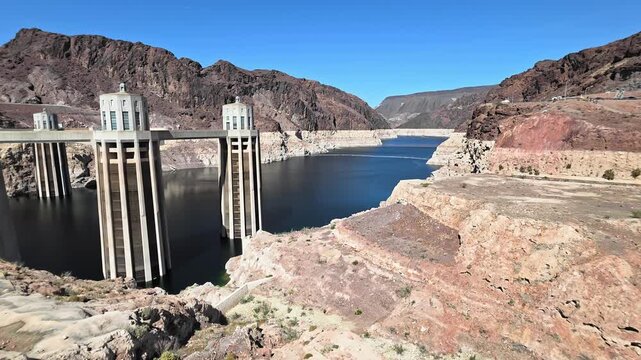 Hoover Dam intake towers and Lake Mead surrounded by desert cliffs, Wide scenic view shows low water levels and monumental engineering landscape