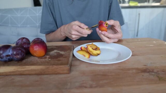 Person Cutting Ripe Nectarine on Wooden Board in Home Kitchen for Fresh Snack video Full HD