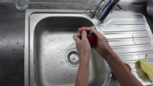Washing ripe red tomato under running water before salad video Full HD preparation