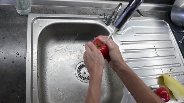 Washing ripe red tomato under running water before salad preparation video Full HD