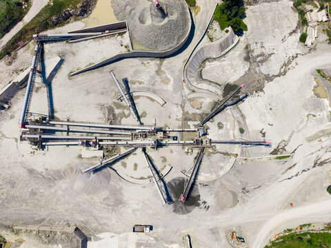 Granite quarry showing machines and paths in operation at a busy mining site in daylight during the work week