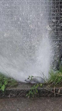 Wasserfont&auml;ne am Stra&szlig;enrand wegen Wasser Leitungsbruch, hochschie&szlig;endes Wasser in Zeitlupe gefilmt