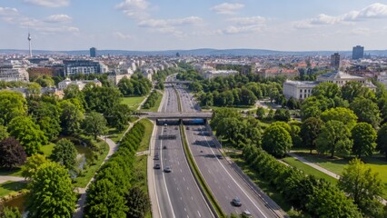 Fototapeta premium An elevated perspective captures a modern highway bustling with cars, flanked by lush green parks and urban architecture, with a prominent tower visible in the distance