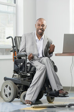 Businessman with Cerebral Palsy working on a computer with his foot