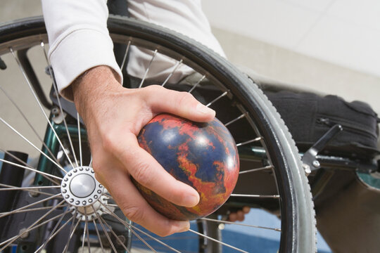 Close-up of a man's hand, with a Spinal Cord Injury, holding a bowling ball